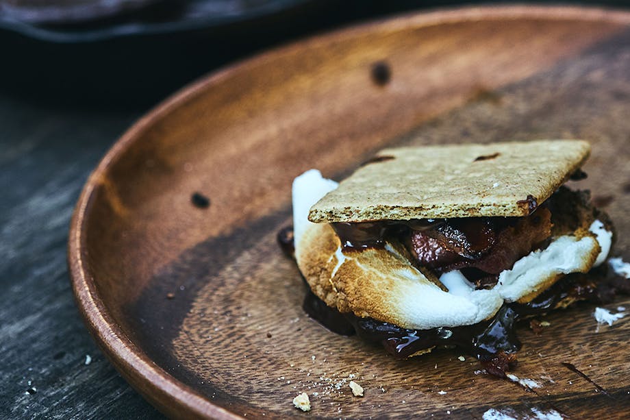 smore with bacon on a wooden plate